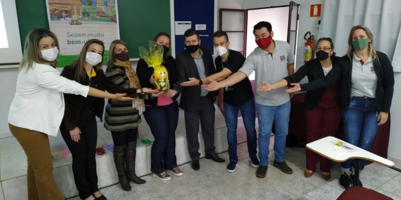 Registro do momento da entrega simbólica de uma pelúcia que é a mascote do programa